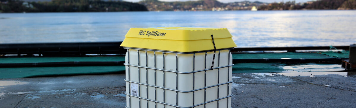 IBC med gul trakt og lokk som står på kai med stille hav i bakgrunn. Foto